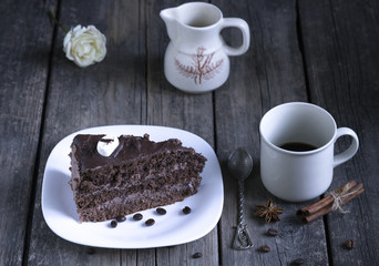 A piece of cake and a cup of coffee on a wooden table