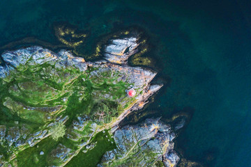 Aerial Top Down over Beautiful Ocean Coast in Scandinavia with Lighthouse and Water Crashing against Rocks