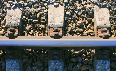 Railroad Tracks Detailed Top View of Concrete Sleepers, Gravel Stones and Metal Rails. Train Railways Industrial Background on Summer Day. Close Up View of Retro Rusty Rail Road Structures