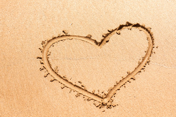 Heart symbol written on the wet sea sand