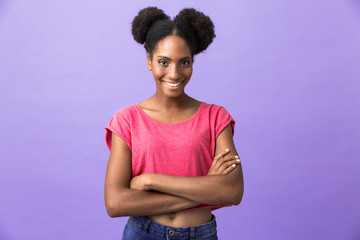 Photo of attractive african american woman with afro hairstyle smiling at camera, isolated over violet background