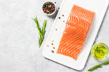 Slice of salmon with pepper, seasalt, herbs and olive oil. Top view, space for text.