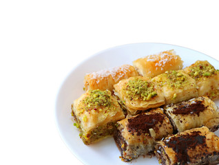 The variety of mouthwatering Baklava pastries served on white plate isolated on white background  with free space for text and design  