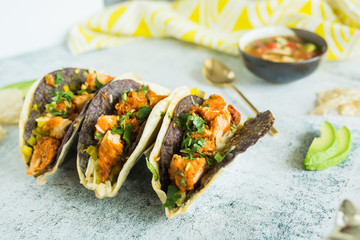 Double-stacked blue corn and flour tortillas tacos
