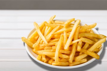 Plate of french fries on wooden table