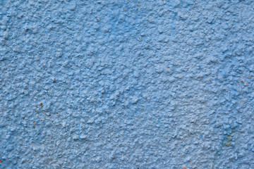 Fototapeta na wymiar The texture of the blue plastered facing of the stone surface of the wall background.