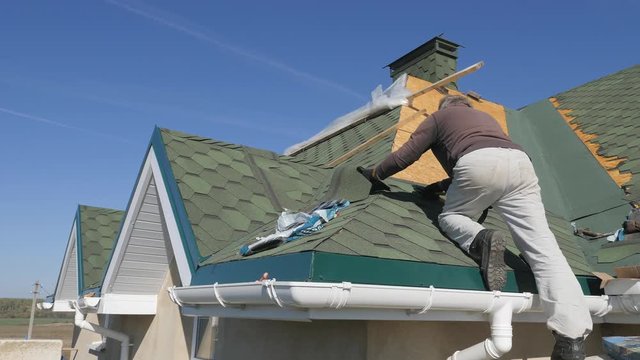 soft roof of shingles. Repair of the roof of a residential house. installation of soft tiles. partial replacement of the damaged roof. Dot repair. Nailing roofing material to the surface of the