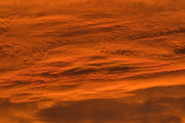 Naklejka premium Chmury zabarwione na czerwono światłem zachodzącego słońca.