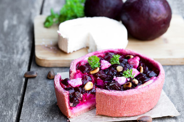 Homemade balsamic beetroot and goat's cheese quiche on wooden table