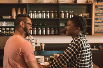 Smiling young couple ordering coffee together in a cafe