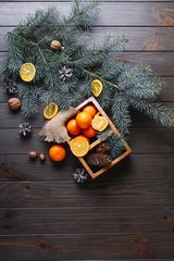 Christmas and New Year decor. Oranges, cones and Christmas tree branches lie on a wooden table