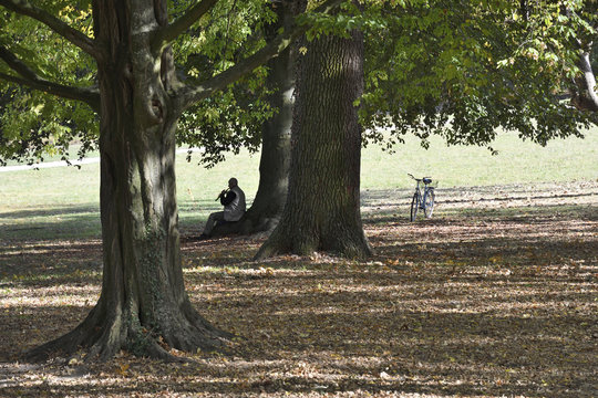  im schlosspark worms-herrnsheim sitzt ein mann und spielt fl&ouml;te