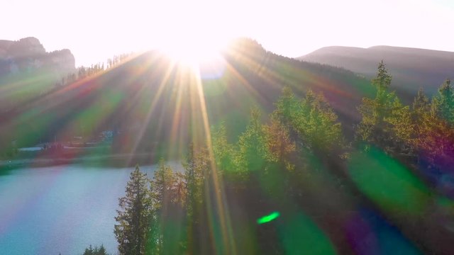 Autumn color forest, aerial view over colorful autumn trees, towards lake. Mountain lake and forest in autumn season. Beautiful sun light. Mountain lake with turquoise water in fall season. October. 
