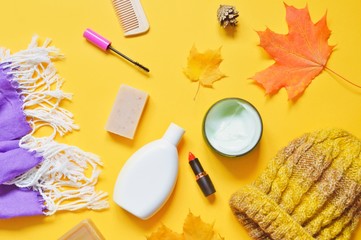 Flat lay women's lifestyle photo. Autumn cosmetics and bath products for skin and hair care. Scarf, shampoo, natural soap, body cream, red lipstick, mascara, comb and yellow woolen hat