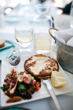 Traditional grilled cheese with salad and slice of lemon on white plate