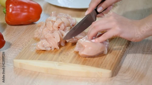Close Up Woman Cuts Chicken Fillet With A Ceramic Knife On A Wooden