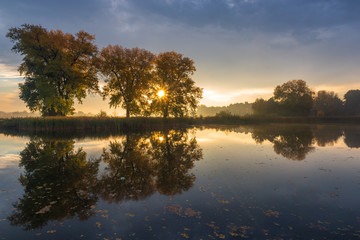 Fototapeta na wymiar Sunrise over the pond at autumn in Falenty near Raszyn, Masovia, Poland