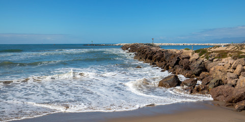 Fototapeta na wymiar Ventura beach and sea rock wall jetty on the California coastline USA