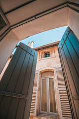 Antique wooden shutters open in the early morning to let in light and fresh morning air