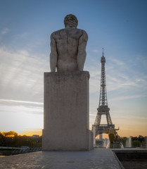 Fototapeta na wymiar Paris, France - 10 13 2018: View of the Eiffel Tower and the back of a man sculpture, from The Trocadero at sunrise