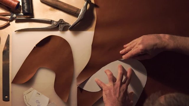 Shoemaker man working with leather using crafting DIY tools.