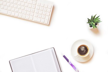 White keyboard, paper notebook, cup of coffee, green plant and purple pen. Flat lay office table, work place. Mockup