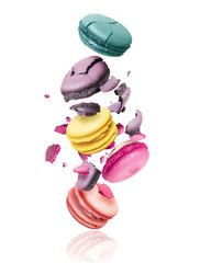 Сolored macaroons crushed into pieces in the air, isolated on a white background