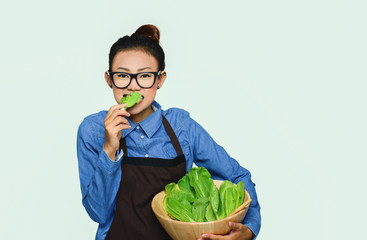 Asian girl eating green vegetable Happy mood.focus on face