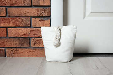 Stuffed bag near white door at home