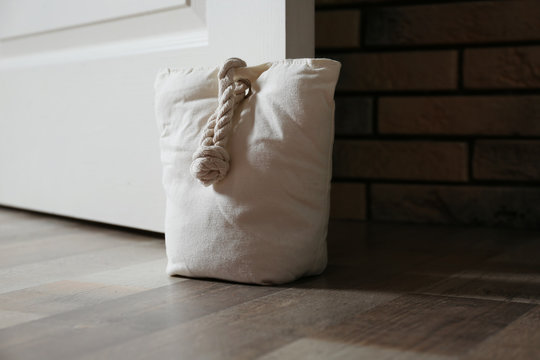 Stuffed bag holding wooden door at home
