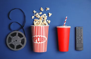 Deurstickers Flat lay composition with popcorn, cinema reel and TV remote on color background © New Africa