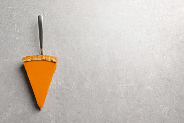 Piece of fresh delicious homemade pumpkin pie on gray background, top view with space for text