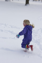 Little girl running through the snow