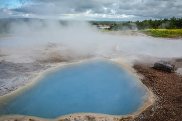 Geyser Park in Iceland -  holes in the ground filled with hot water with steam coming from them