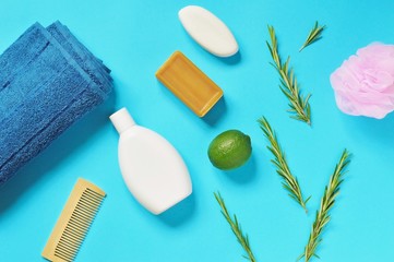 Flat lay organic herbal cosmetics. Natural bath products. Shampoo, brown handmade soap, rosemary herbs, line, pink sponge and terry towel