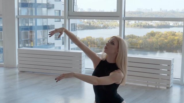 closeup portrait of a woman. graceful female hands on the background of the window. ballerina in black tutu dancing in the dance hall. slowmotion HD