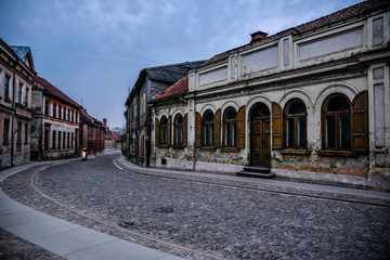 Street of Kuldiga old town, Latvia. Beautiful old buildings and pebble stone pathway with motorcycle seen far away.