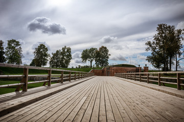 Emperor gates and wooden bridge in Daugavpils fortress, Latvia against dramatic autumn skies. 