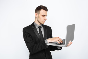 A successful man, in a black suit, looks thoughtfully into a laptop, a Bank employee, on a white background, black Friday,