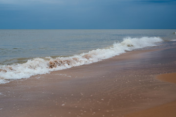 White sand beach with waves and blue sky on cold summer day in Latvia, Pavilosta