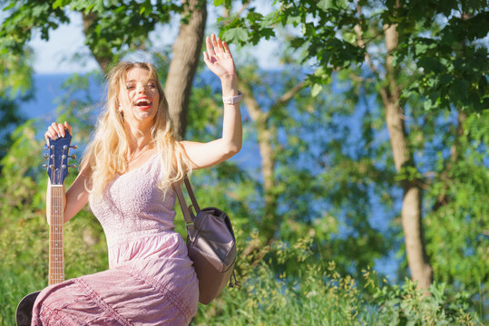 Woman playing acoustic guitar in park