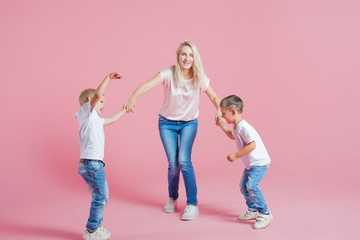 Fototapeta premium Beautiful blonde mom with two happy sons. Young woman and two baby boys