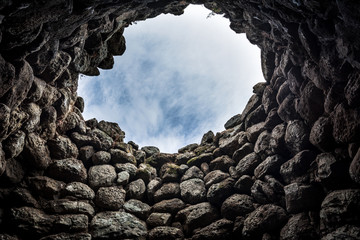 Typical nuraghe interior with overhead opening to allow light in it in Sardinia, Italy. Nuragic sites are archaeological remnants of prehistoric building of bronze age, ancient civilization. 