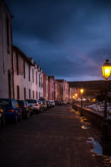 Night city view after rain in the street of Bosa, Sardinia, Italy with lantern switched on.