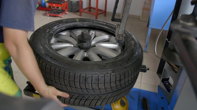 4K Close up shot tyre fitter is disassembling tyre from a wheel on a special tool
