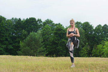 Fit women stretching the muscles of her legs