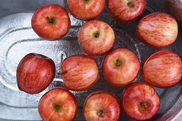 a metal tub filled with water and apples for the Halloween custom of Apple Bobbing