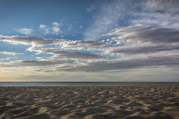 Empty beach early in the morning  in Costa Rei, Sardinia, Italy. Beautiful clouds, sunrise and sandy beach. Nobody in the scene.