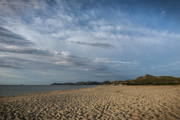 Empty beach early in the morning in Costa Rei, Sardinia, Italy. Beautiful clouds, sunrise and sandy beach. Nobody in the scene.