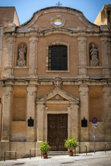 Exterior of Chiesa Santa Rosalia church at Cagliari, Sardinia, Italy on a sunny day with blue sky. Located in downtown Cagliari, nobody in the scene. Photo gives the feel how steep the street is.